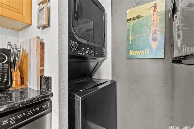 clothes washing area with stacked washer and dryer