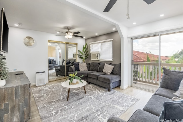 living room with cooling unit, ceiling fan, and light hardwood / wood-style floors