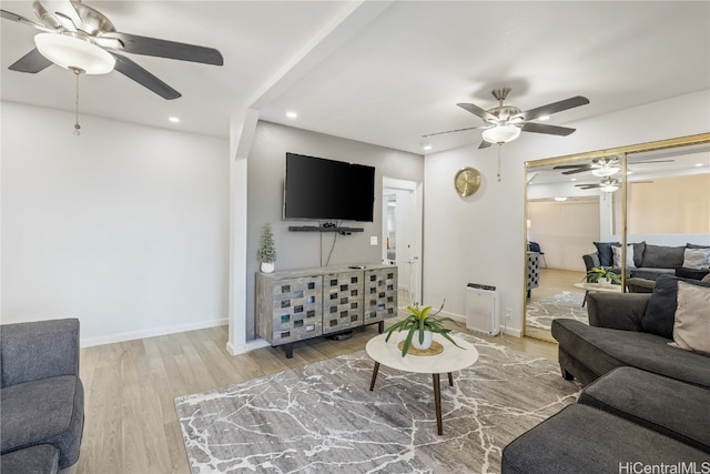 living room featuring ceiling fan and hardwood / wood-style floors