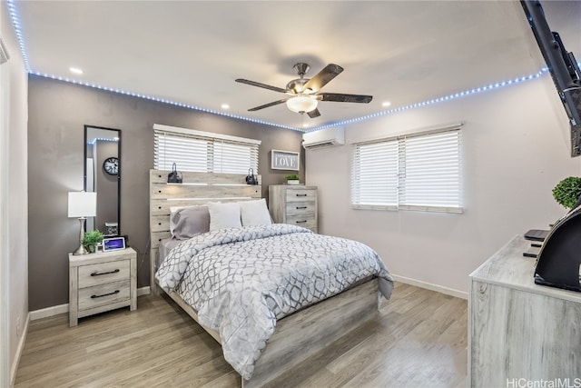 bedroom with hardwood / wood-style floors, a wall mounted air conditioner, and ceiling fan