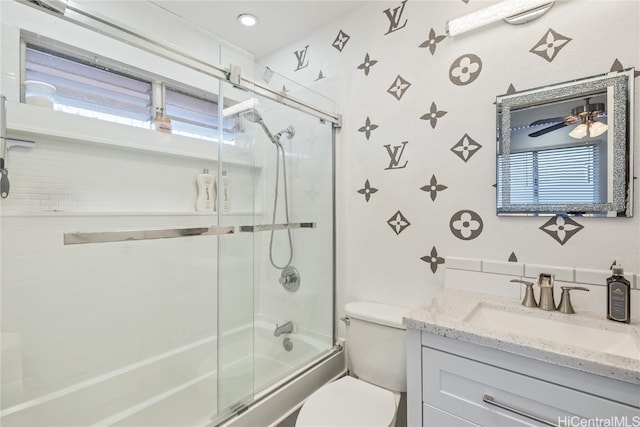 full bathroom featuring enclosed tub / shower combo, a healthy amount of sunlight, toilet, and vanity