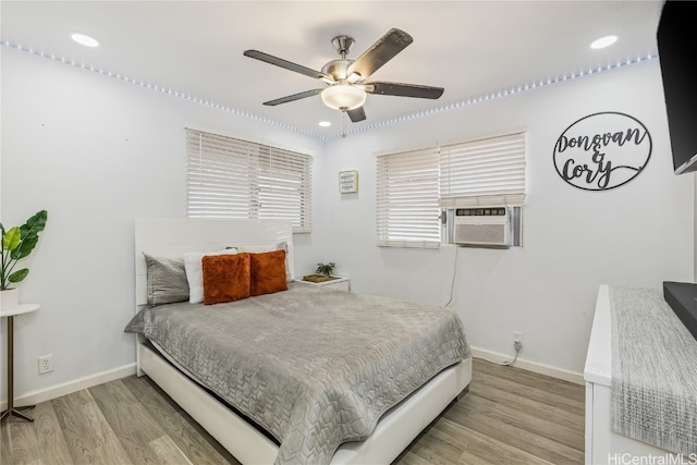 bedroom featuring ceiling fan, cooling unit, and light wood-type flooring