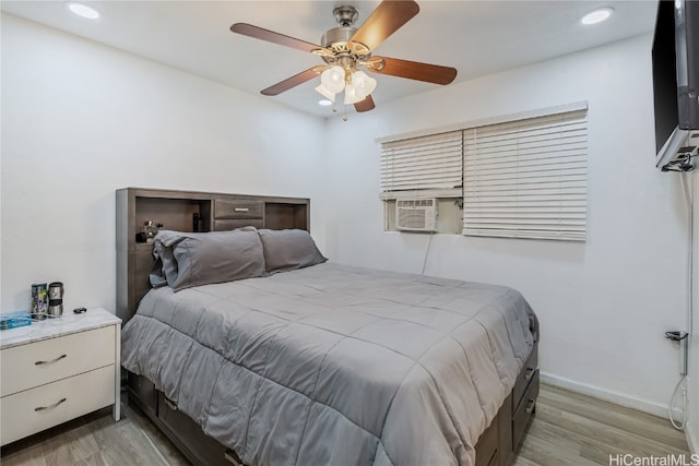 bedroom featuring cooling unit, ceiling fan, and light hardwood / wood-style flooring