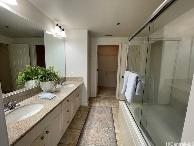 bathroom with a shower with door and vanity