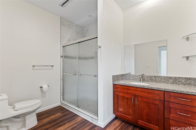 bathroom with an enclosed shower, vanity, hardwood / wood-style flooring, and toilet