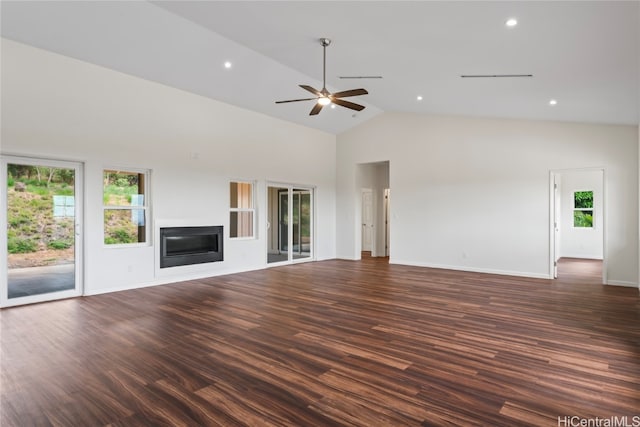 unfurnished living room featuring dark wood-type flooring, a wealth of natural light, high vaulted ceiling, and ceiling fan