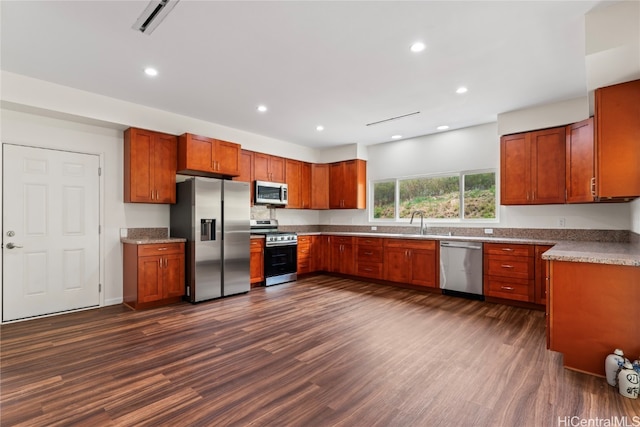 kitchen with appliances with stainless steel finishes, dark hardwood / wood-style floors, and sink