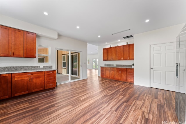 kitchen with light stone counters and dark wood-type flooring