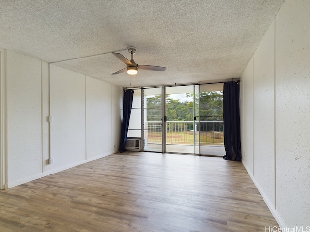 unfurnished room featuring cooling unit, a textured ceiling, light hardwood / wood-style floors, and ceiling fan