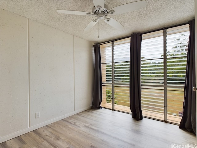 unfurnished room with ceiling fan, a textured ceiling, and light hardwood / wood-style flooring