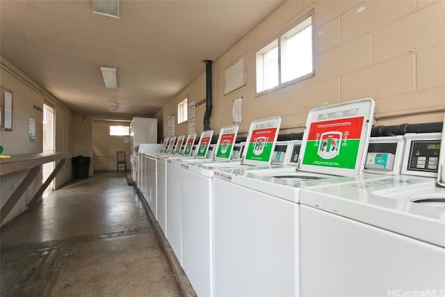 clothes washing area featuring plenty of natural light and washer and clothes dryer