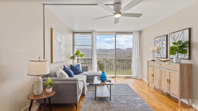 living room with ceiling fan and light hardwood / wood-style flooring