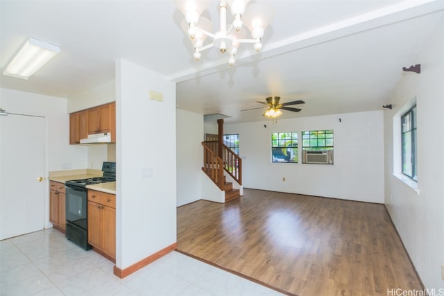 kitchen featuring exhaust hood, light hardwood / wood-style flooring, cooling unit, black range, and ceiling fan with notable chandelier