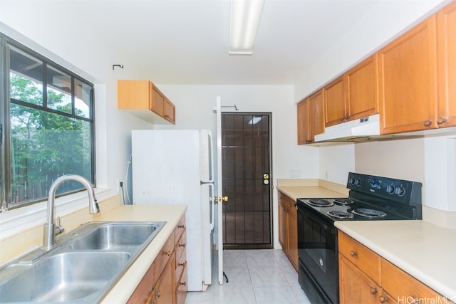 kitchen with sink, black / electric stove, and white fridge