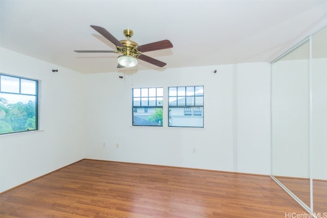 empty room with ceiling fan and hardwood / wood-style floors