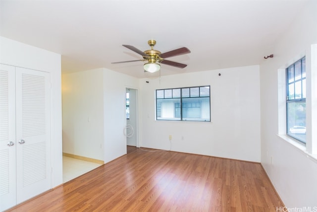 unfurnished room featuring light hardwood / wood-style floors, a healthy amount of sunlight, and ceiling fan