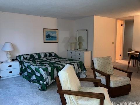 bedroom with light colored carpet and a textured ceiling