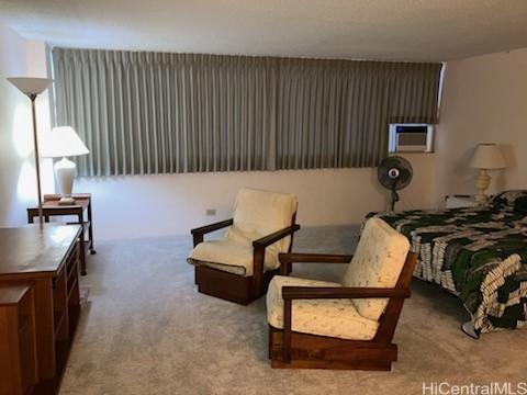 bedroom featuring light carpet, cooling unit, and a textured ceiling