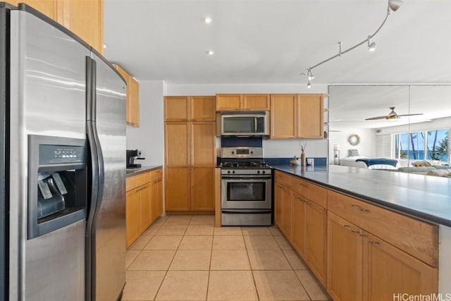 kitchen featuring stainless steel appliances, ceiling fan, and light tile patterned flooring