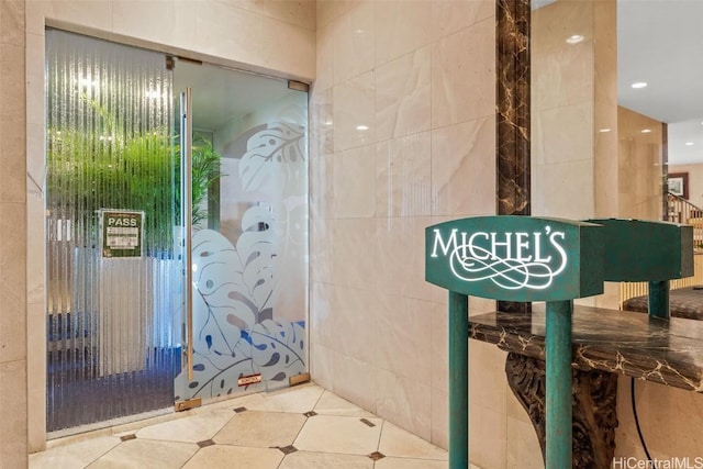 bathroom with tile patterned flooring and tile walls