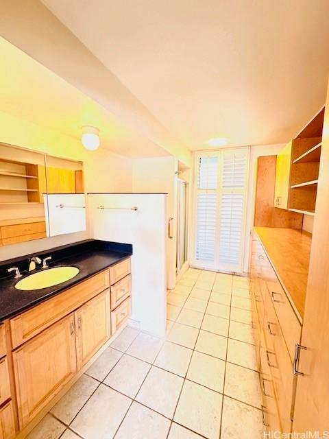 kitchen featuring light brown cabinetry, sink, and light tile patterned floors