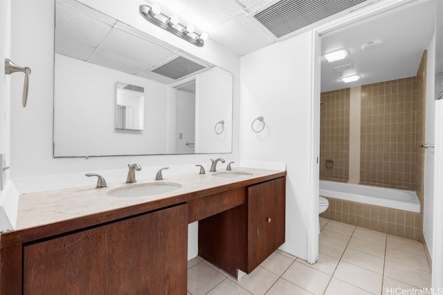 full bathroom with vanity, tiled shower / bath combo, toilet, and tile patterned flooring