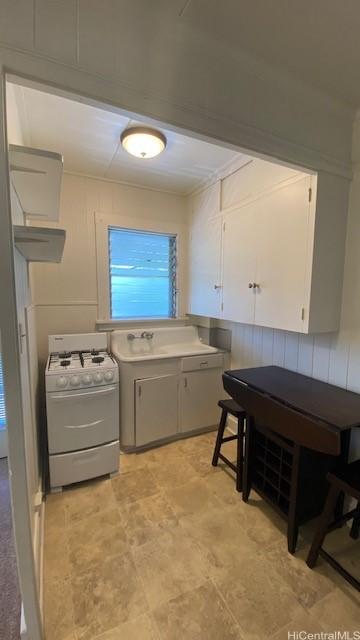 914 Kinau St, Honolulu, HI 96814 - kitchen featuring white gas range oven, white cabinets, and a sink