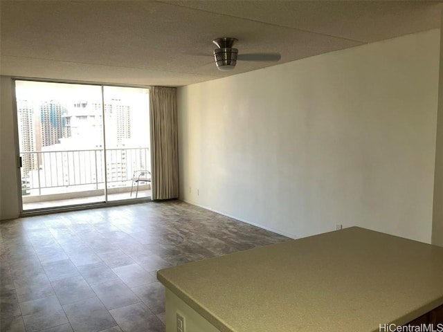 empty room with floor to ceiling windows and ceiling fan