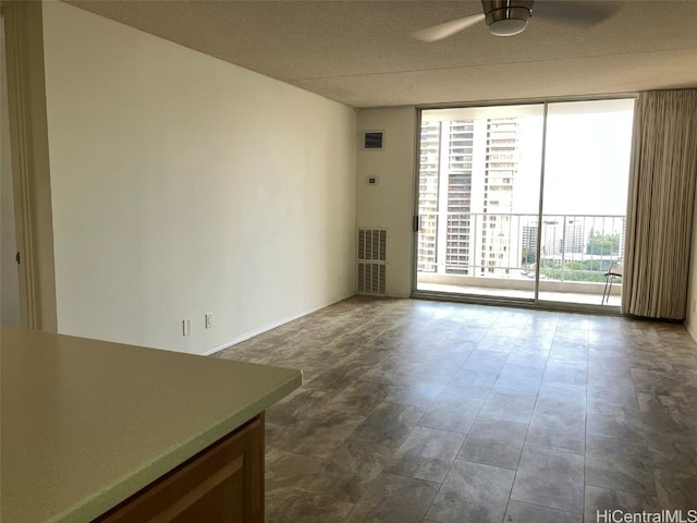 unfurnished room featuring floor to ceiling windows and ceiling fan