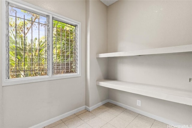 interior space with light tile patterned floors, baseboards, and a healthy amount of sunlight