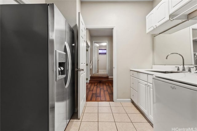 kitchen with a sink, white cabinetry, stainless steel fridge with ice dispenser, light tile patterned floors, and dishwasher