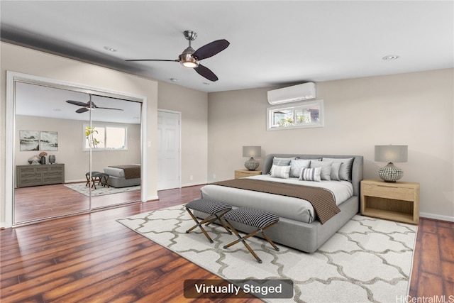 bedroom featuring an AC wall unit, a ceiling fan, wood finished floors, recessed lighting, and baseboards