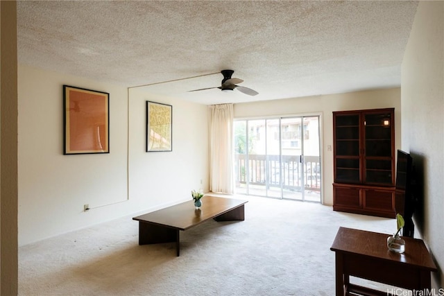 carpeted living room with a textured ceiling and ceiling fan