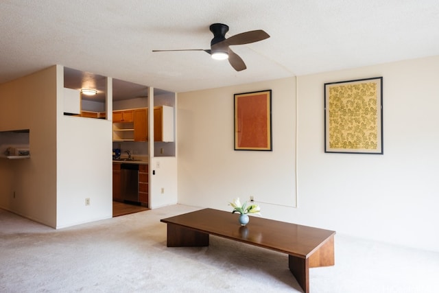 unfurnished living room with a textured ceiling, ceiling fan, sink, and light carpet