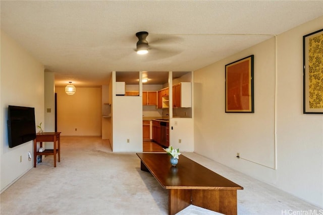 carpeted living room featuring ceiling fan and sink