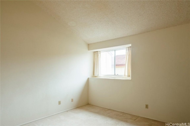 spare room with a textured ceiling and light carpet