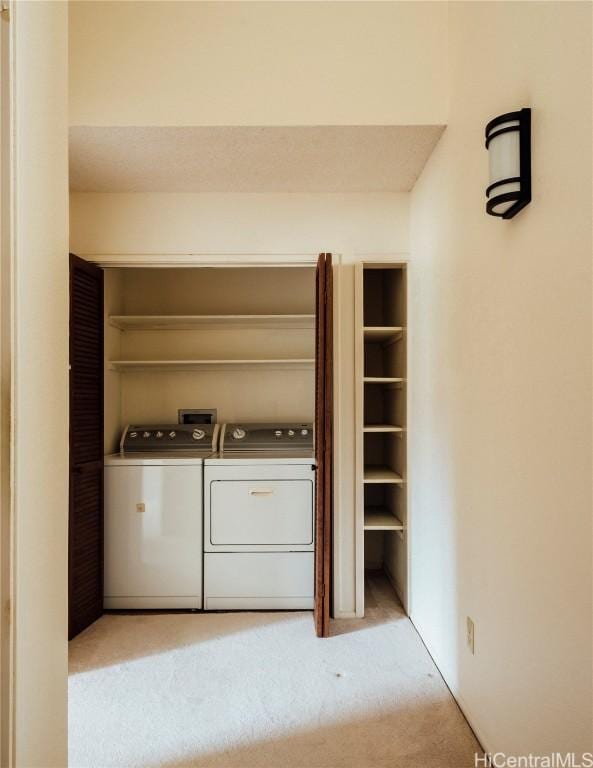 laundry area with light carpet and washer and clothes dryer