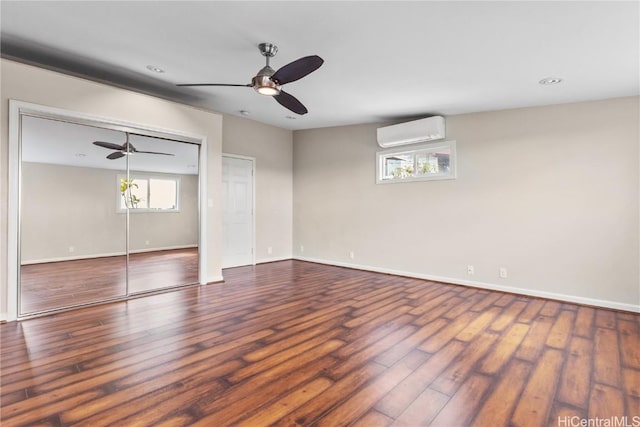 unfurnished room with ceiling fan, hardwood / wood-style floors, and a wall mounted air conditioner