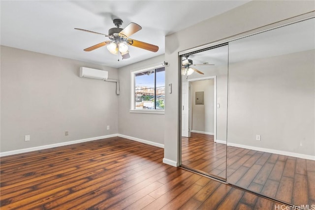 unfurnished bedroom with ceiling fan, dark hardwood / wood-style floors, electric panel, a wall unit AC, and a closet