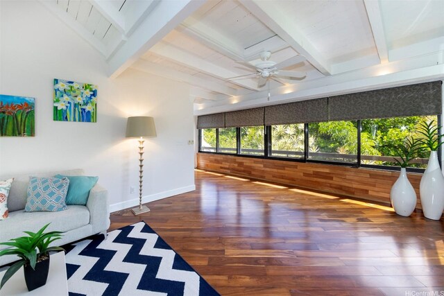 living area with baseboards, beamed ceiling, a ceiling fan, and wood finished floors