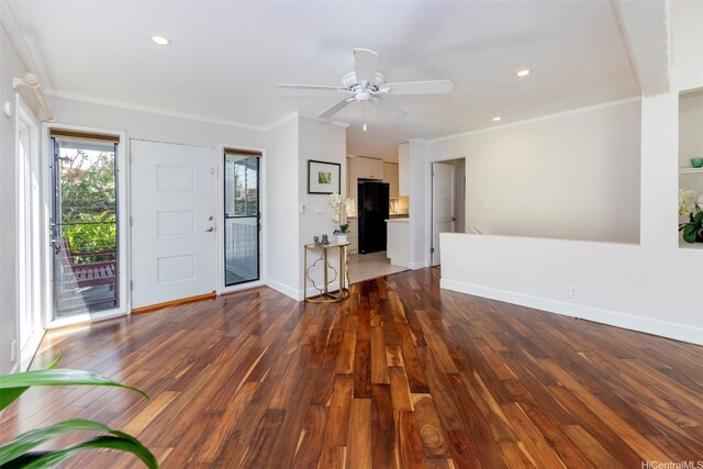 unfurnished living room featuring crown molding, baseboards, ceiling fan, and wood finished floors