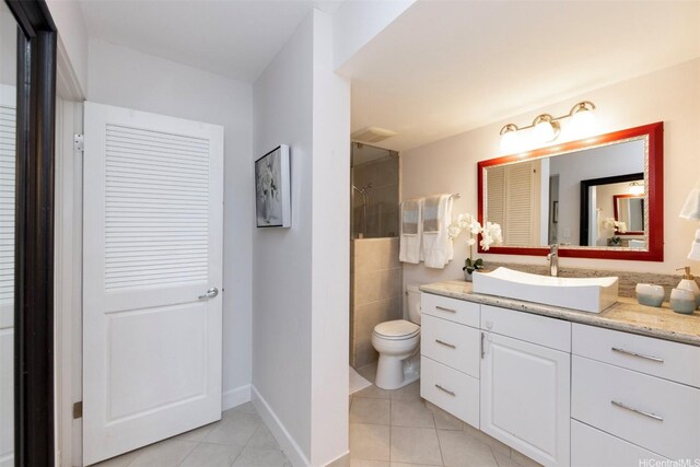 full bathroom featuring vanity, a closet, toilet, tile patterned floors, and a tile shower