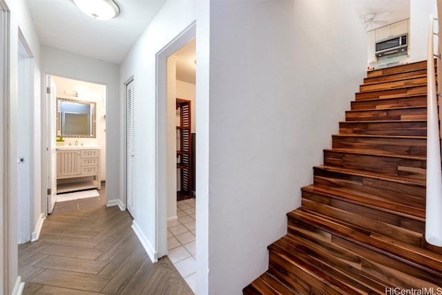 stairway featuring sink and parquet floors