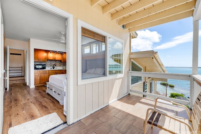 balcony featuring a water view and sink