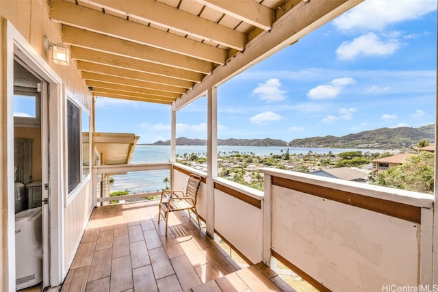 balcony featuring a water and mountain view