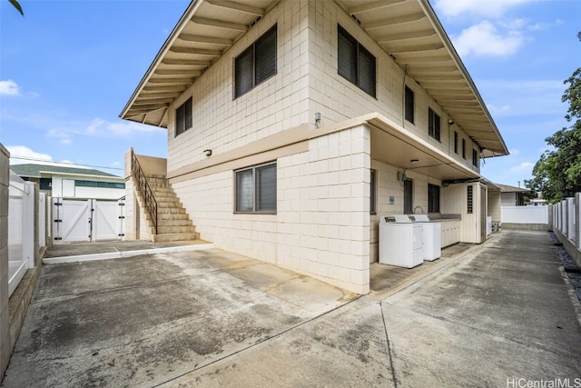 view of home's exterior with independent washer and dryer and a patio