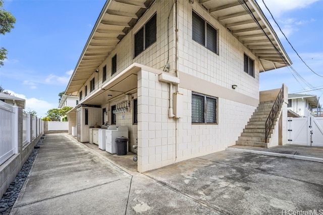 view of property exterior with washing machine and clothes dryer