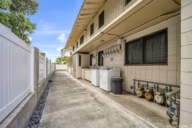 view of property exterior featuring a patio, sink, and separate washer and dryer