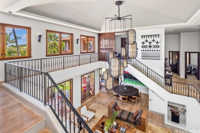 interior space featuring wood-type flooring, a tray ceiling, and a chandelier