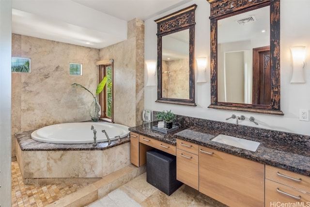 bathroom featuring vanity and a relaxing tiled tub